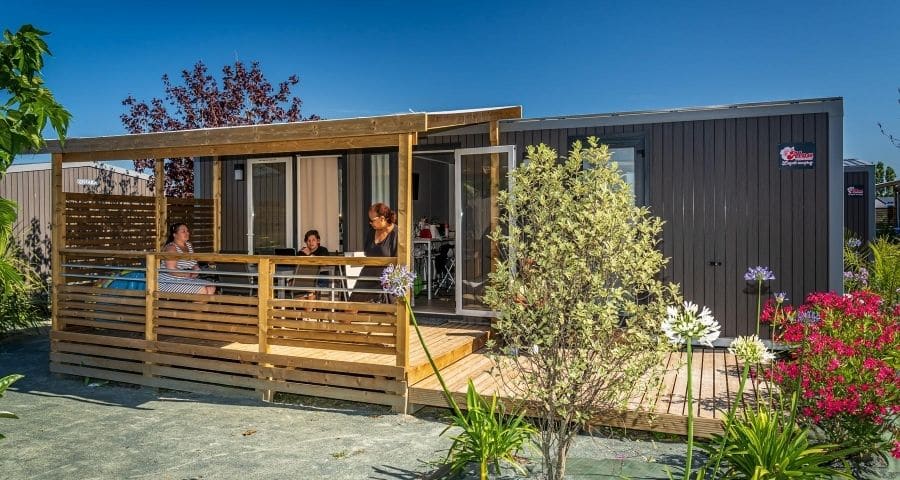 Vue extérieure d'un mobil-home avec terrasse en bois au camping Nid d'Été aux sables d'Olonne