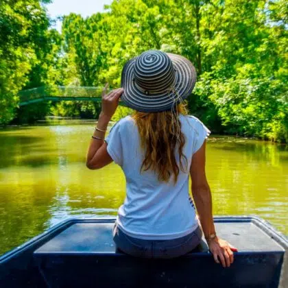 vendée en camping-car 21 Rear view of woman with hat on boat looking at river- Marais poitevin in France